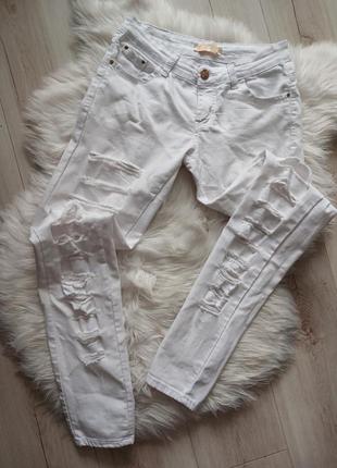 Білі скінні стрейчеві завужені порізані білі джинси в обтяжку