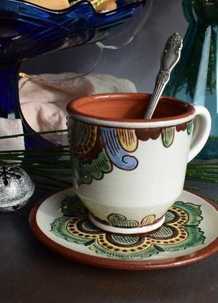 A ceramic mug with a saucer