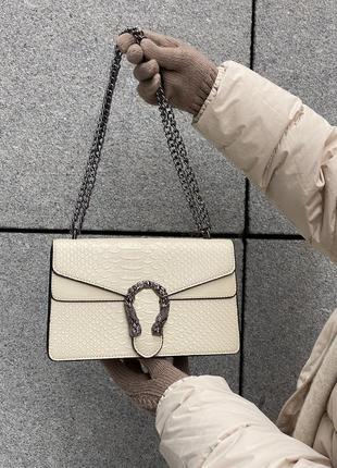 Женская сумка кросс-боди рептилия с железной подковой белая1 фото