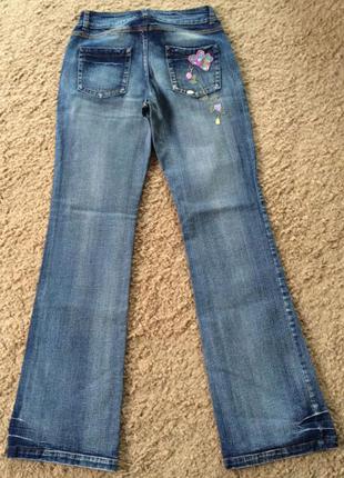 Стрейчевые расклешённые джинсы с вышивкой 44-462 фото