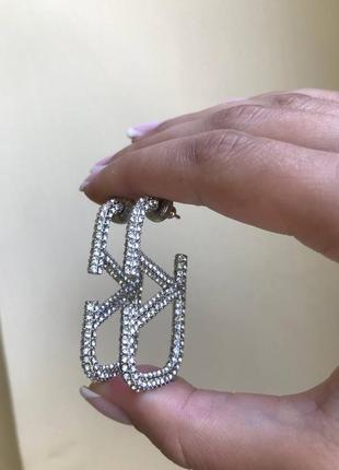 Брендовые серьги серебряного цвета в цирконах