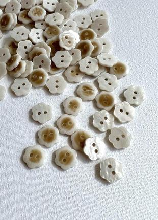 Пуговица рубашечная цветок 2отв бежевая 11мм пластик