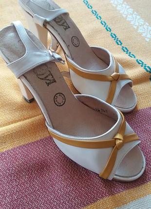 Білі шкіряні босоніжки з жовто-помаранчевим кантом на стійкому каблуці.