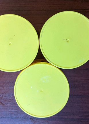 Три большие жёлтые баночки с крышками из-под крема cococare.10 фото