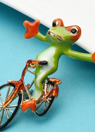 Брошка металева жаба на велосипеді велика