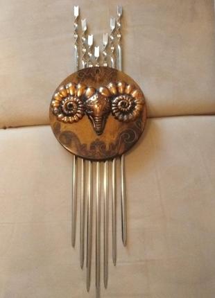 Шампура в настенном панно с чеканкой-головой барана.