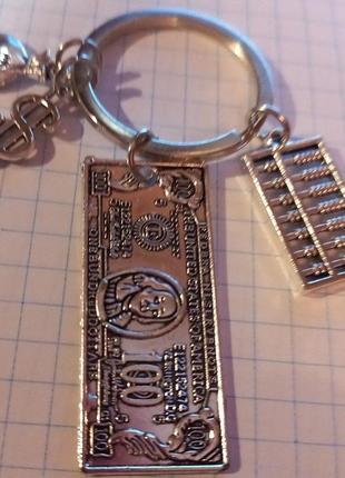 Брелок металл деньги баксы зелень капуста мешок денег счеты сувенир купюра 100 долларов серебристый