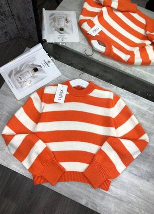 Женский свитер в оранжевой полоске.