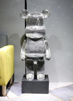 Фигурка bearbrick серебряного цвета на подставке supreme 155 см. дизайнерская игрушка беарбрик. фигурка