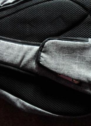Сірий рюкзак через груди, з окремою кишенькою для телефона.