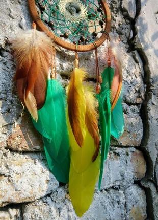 Коричневый ловец снов с желтыми и зелеными перьями из натуральных материалов.7 фото