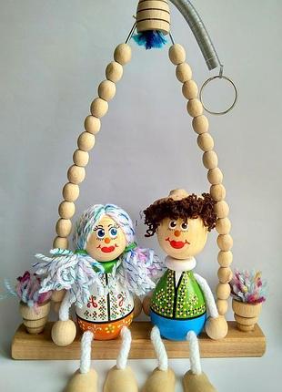Дерев'яні ляльки на гойдалках