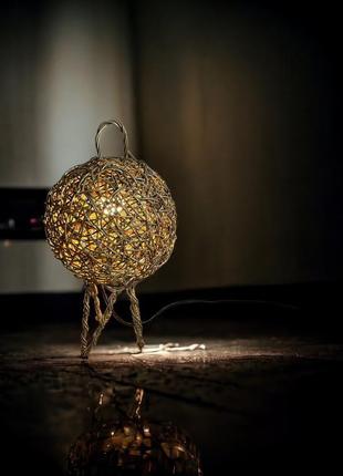 Напольный светильник из искусственного ротанга на металлическом каркасе.