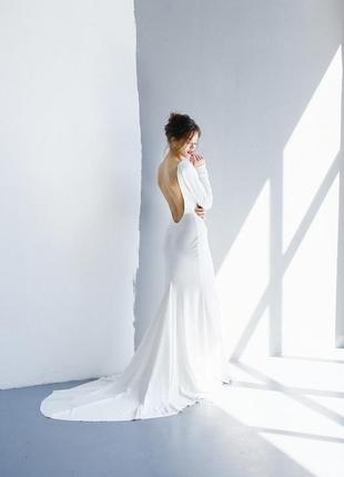 Мінімалістична весільна сукня з довгими рукави, відкритою спиною та довгим шлейфом. силует русалки