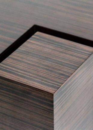 Дизайнерський журнальний столик з дерева зі скляною стільницею.