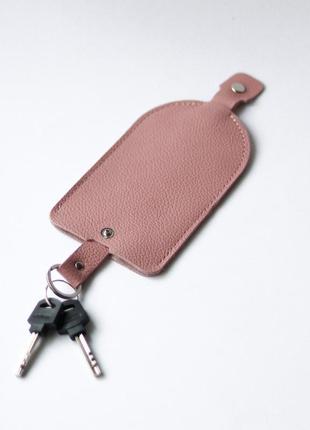 Ключниця з рухомим тримачем ключів на кнопці рожева з перфорацією.1 фото