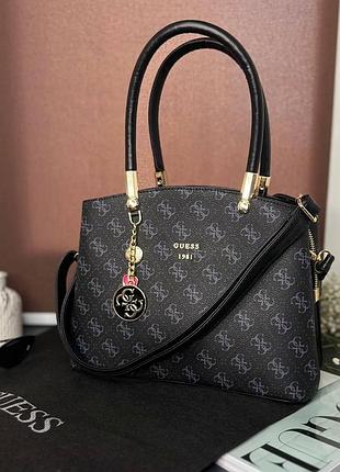 Женская черная сумка guess с ручками и плечевым ремнем.