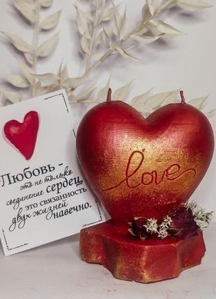 Свічка "love is..." до дня закоханих у формі серця на п'єдесталі з декором