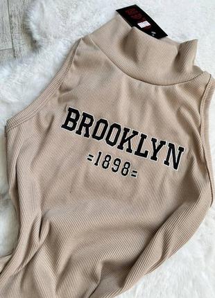 Платье brooklyn в рубчик короткая с высоким воротником под горло платья майка мини без рукавов стильная базовая черная бежевая5 фото