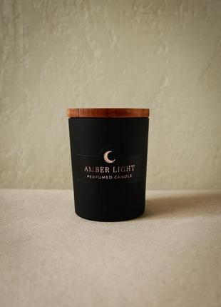 Парфумована свічка "amber light" у чорній скляній ємності з дерев'яною кришкою8 фото