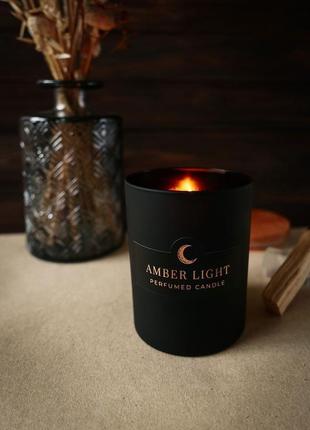 Парфумована свічка "amber light" у чорній скляній ємності з дерев'яною кришкою9 фото