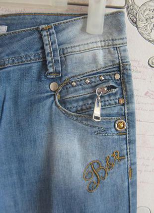 Джинсы узкие потертые голубые с молниями на карманах4 фото