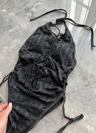 Стильний чорний суцільний купальник  зі шнуровкою по центру та боках4 фото