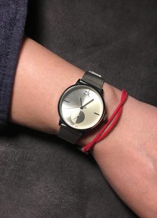 Часы с металлическим ремешком серебряного цвета.