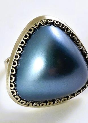 Крупное серебряное кольцо с треугольной вставкой.