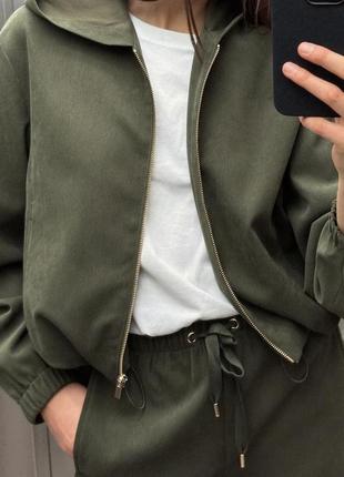 Фактурный брючный костюм в цвете хаки с кофтой на молнии и прямыми штанами