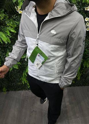 Мужская куртка-ветровка lacoste на зиму в серо-белом цвете из качественного материала стильная и удобная