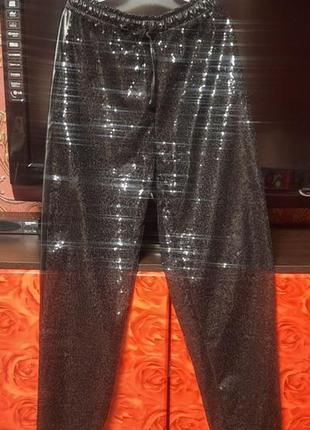 Черные брюки в пайетках с вставками экокожи.