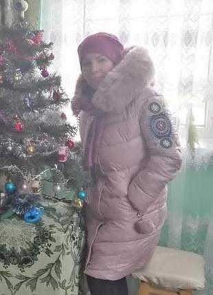Стильный пуховик с вышивкой на рукавах.