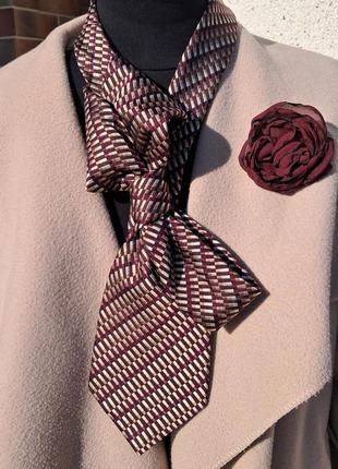 Роскошный женский галстук бордовых оттенков с цветочкой брошью.
