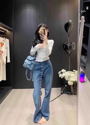 Джинси з ґудзиками по штанині