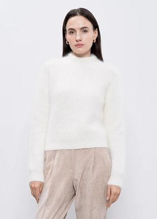 М'який светрик під горло білого кольору.