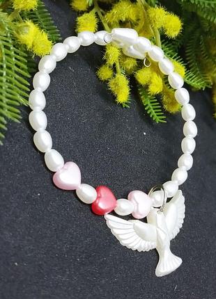 Браслет на карбоновой проволоке не замкнут с подвеской в виде горлицы.