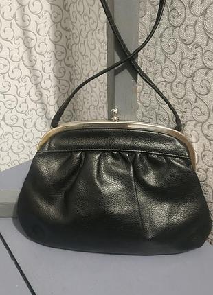 Небольшая черная сумочка на длинном ремне.