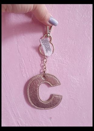 Золотистий брелок с, від monsoon