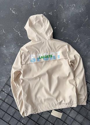 Мужская бежевая куртка ветровка с большой надписью на спине lacoste