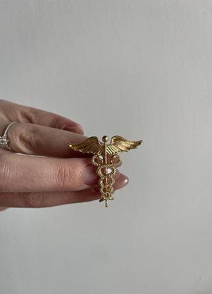 Металева брошка кадуцей — символ медицини