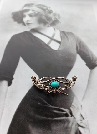 Винтажная серебряная брошь с голубой вставкой.
