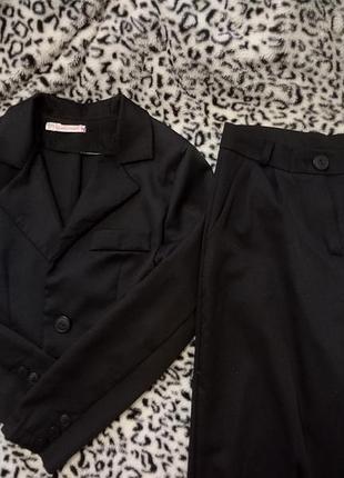 Костюм классический, черный, с укороченным пиджаком.