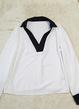 Біла жіноча блуза з чорним комірцем