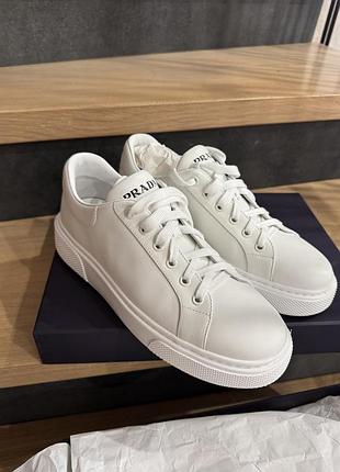 Білі шкіряні кеди prada