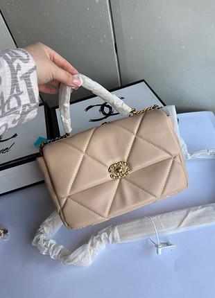 Сумка бежевого кольору у стилі шанель