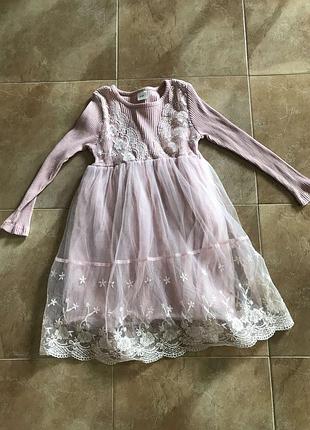 Гарне рожеве трикотажне плаття для дівчинки, прикрашене мереживом.