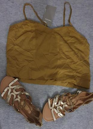 Пакет вещей из шелковой майки и золотистых босоножек