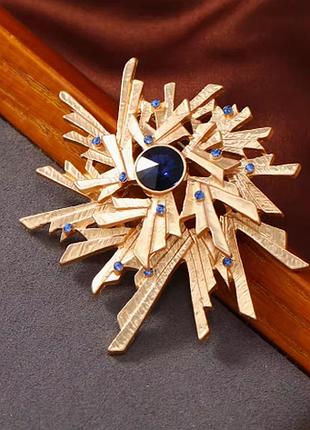Брошь лучи с синими кристаллами матово золотистая бижутерия
