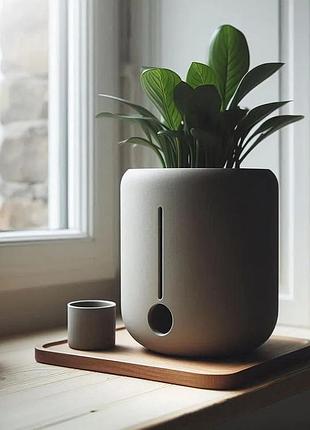 Минималистичный круглый горшок для растений с интегрированной камерой для воды.